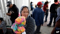 Maria Rafaela Blancante, of the Mexican state of Michoacan, holds her daughter, Jazmin, as they wait with other families to request political asylum in the United States, across the border in Tijuana, Mexico.