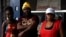 Haitian immigrant Wilthene Pierre is pictured with two of his cooks Emily, left, and Violette Novembre, in front of the Kriskapab Baborijinal Haitian restaurant in Tijuana, Mexico, Nov. 22, 2018. The cafe serves dishes of coconut rice, mashed plantains and goat stew.
