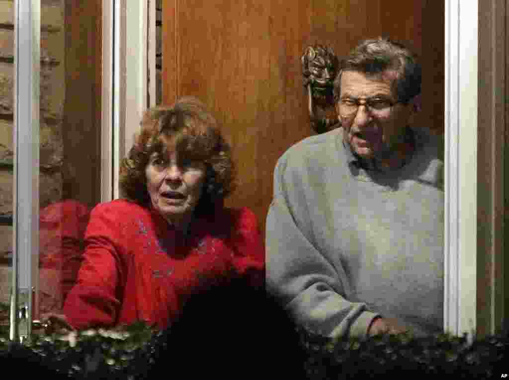 Joe Paterno and his wife, Susan, come to the doorway of their home to thank supporters gathered outside their home after John Surma, chairman and chief executive officer of the Penn State Board of Trustees, announced the firing of Paterno as head football