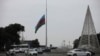 An Azeri state flag flies at half-mast as the country observes the day of national mourning for the victims of an Azerbaijan Airlines' Embraer passenger plane crash near the Kazakh city of Aktau, in a square in Baku, Dec. 26, 2024. 