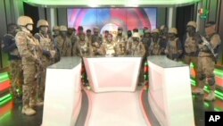 In this image from video broadcast by RTB state television, coup spokesman Capt. Kiswendsida Farouk Azaria Sorgho reads a statement in a studio in Ougadougou, Burkina Faso, on Friday evening, Sept. 30, 2022.