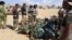 Libyans gather around the remains of a helicopter that crashed near Benghazi, Libya, July 20, 2016.