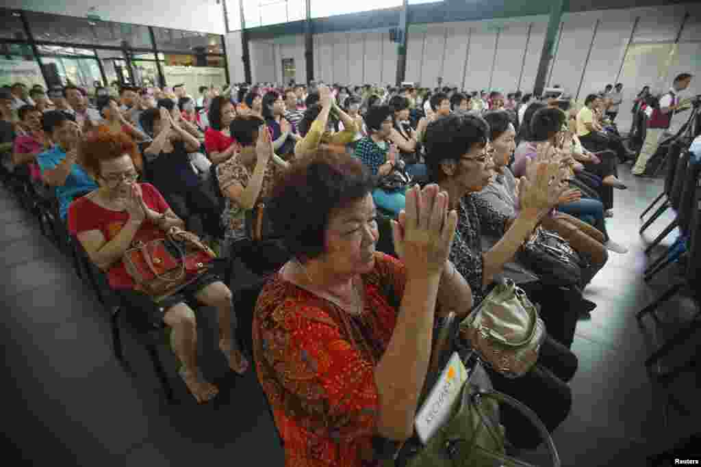 People take part in a special prayer for passengers onboard Flight MH370, at Kechara retreat center in Bentong, outside Kuala Lumpur, April 13, 2014. 