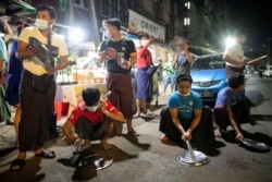 People hit pots during a night protest against the military coup in Yangon, Myanmar February 4, 2021.