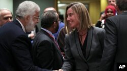 Libya's Foreign Minister Mohamed Taher Siala, left, shakes hands with European Union Foreign Policy chief Federica Mogherini during an EU-Arab League ministerial meeting at the European Council headquarters in Brussels, Monday, Feb. 4, 2019. 