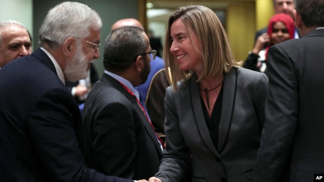 Libya's Foreign Minister Mohamed Taher Siala, left, shakes hands with European Union Foreign Policy chief Federica Mogherini during an EU-Arab League ministerial meeting at the European Council headquarters in Brussels, Monday, Feb. 4, 2019. 