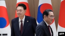 FILE - South Korea's President Yoon Suk Yeol, left, and Japan's Prime Minister Fumio Kishida move their positions during a meeting at the Presidential Office in Seoul on May 26, 2024.