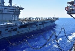 The U.S. Navy aircraft carrier USS Nimitz receives fuel from the Henry J. Kaiser-class fleet replenishment oiler USNS Tippecanoe during an underway replenishment in the South China Sea July 7, 2020.