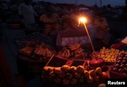 A gas-lamp is seen at a fruit stall during a power outage in Rawalpindi, June 3, 2013.