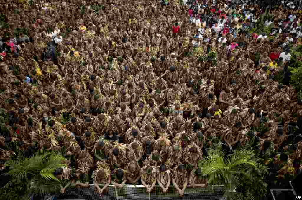 Devotees wearing costumes made of banana leaves attend a Mass as part of a religious festival in honor of St. John the Baptist, also known locally as the &quot;mud people&quot; festival, in Aliaga town, Nueva Ecija province, north of Manila, the Philippines.