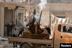 FILE - Free Syrian Army fighters fire an anti-aircraft weapon towards forces loyal to Syria's President Bashar al-Assad in the Handarat area, north of Aleppo, Nov. 30, 2014.