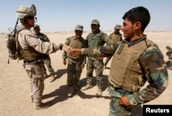 FILE - A U.S. Marine shakes hands with Afghan National Army (ANA) soldiers during a training exercise in Helmand province, Afghanistan, July 5, 2017. Helmand was the scene of an errant U.S. drone strike Friday.