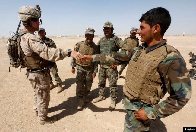FILE - A U.S. Marine shakes hands with Afghan National Army (ANA) soldiers during a training exercise in Helmand province, Afghanistan, July 5, 2017.