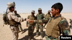 FILE - A U.S. Marine shakes hands with Afghan National Army (ANA) soldiers during a training exercise in Helmand province, Afghanistan, July 5, 2017. 