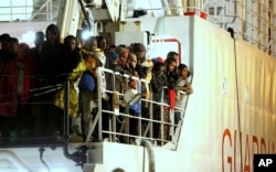 Rescued migrants wait to disembark from an Italian Coast Guard ship in the harbor of Palermo, Sicily, southern Italy, April 14, 2015.