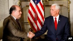 Pemimpin oposisi Venezuela, Julio Borges (kiri), bersalaman dengan Wapres AS Mike Pence (kanan), dalam pertemuan di kediaman duta besar AS di Lima, Peru, 13 April 2018.