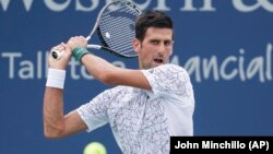 Novak Đoković u duelu sa Francuzom Adrijanom Manarinom u drugom kolu turnira u Sinsinatiju (Foto: AP/John Minchillo) 