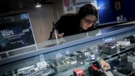 In this Tuesday, Oct. 8, 2019, photo Spike Babaian, owner of several Vape New York stores, works in her East Harlem store in New York.