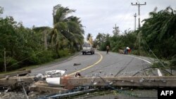5일 열대성 폭풍 '파북'이 지나간 태국 나콘 시 타마랏 주 도로에 전신주가 쓰러져 교통을 막고 있다.