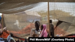 A woman stands with her daughter in the Médecins Sans Frontières (MSF) clinic set up at the camp for displaced people in the grounds of the United Nations Mission to South Sudan (UNMISS) base in Juba, South Sudan, on January 12, 2014.