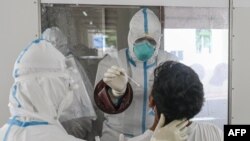 ရန်ကုန်မြို့ လှိုင်တက္ကသိုလ်ထဲက ကွာရမ်တင်းစင်တာမှာ COVID-19 စစ်ဆေးဖို့ Swab နမူနာယူနေတဲ့ ကျန်းမာရေးဝန်ထမ်းများ။ (ဇူလိုင် ၁၆၊ ၂၀၂၀)