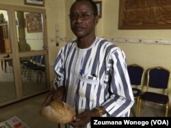 Le vulgarisateur du mung bean Larlé Naba posant avec le pain qui gagné la médaille de bronze, au Burkina Faso, le 11 mars 2017. (VOA/