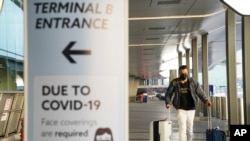 25일 미국 뉴욕 라과르디아 공항에 신종 코로나바이러스 방역 지침 안내문이 세워져있다.