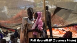 A woman stands with her daughter in the Médecins Sans Frontières (MSF) clinic at the camp for displaced people on the grounds of the United Nations Mission to South Sudan base in Juba, South Sudan, on January 12, 2014.