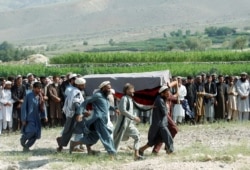 FILE - Men carry a coffin of one of the victims after a drone strike, in Khogyani district of Nangarhar province, Afghanistan, Sept. 19, 2019.