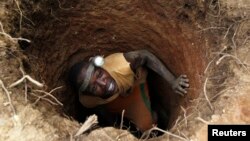 Un 'creuseur' s’introduit dans un trou à la recherche d’or dans le village de Bouafle, près de la frontière entre le Ghana et la Côte d'Ivoire, 18 mars 2014.