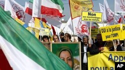 Iranian dissidents wave their national flag and various Islamic flags during a demonstration, July 10, 2008, in front of the European Parliament in Strasbourg, France, to have the People's Mujahedeen Organization of Iran removed from the EU terror list