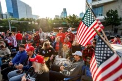 Supporters of President Donald Trump wait to enter a campaign rally as the sun rises, Oct. 17, 2019, outside the American Airlines Center in Dallas.