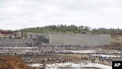 Guest and workers look on as the basin of the under-construction port at Hambantota is being filled with sea water, 15 Aug 2010