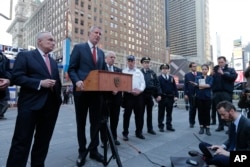 New York City Police Commissioner Bill Bratton, left, listens as New York City Mayor Bill de Blasio speaks during a news conference in Times Square about security enhancements in the city, March 22, 2016.