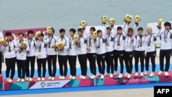018 자카르타·팔렘방 아시안게임 여자 카누 용선 200m 대회에 참가한 남북 단일팀이 금메달을 목에 걸고 있다.