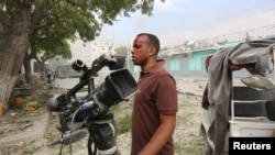 FILE - Somali Freelance journalist Mohamed Guray holds on to his camera after he was injured in a secondary explosion in front of Dayah hotel in Somalia's capital Mogadishu, Jan. 25, 2017.