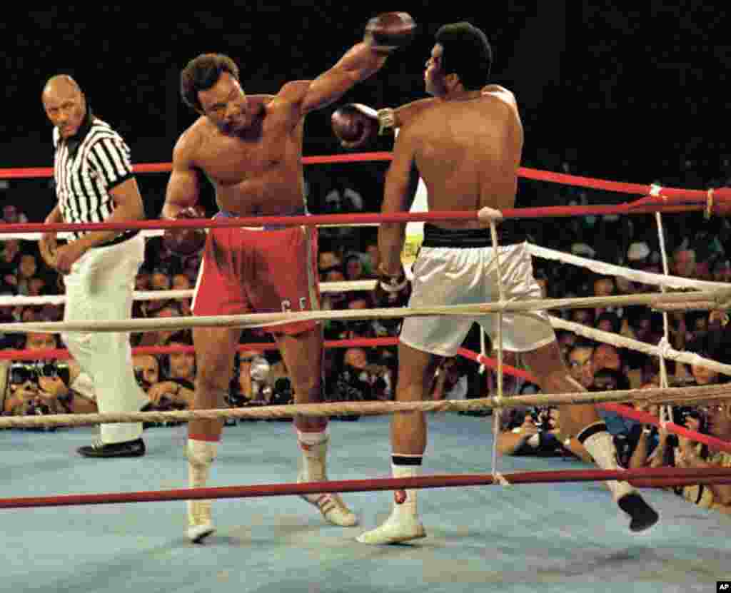 Muhammad Ali, à droite, dévie un coup de poing de George Foreman, culotte rouge, à Kinshasa, au Zaïre, le 29 Octobre, 1974. Ali a remporté le combat en Afrique par un knock-out au cours du 8ème tour. Zack Clayton est l&rsquo;arbitre. (AP Photo) 