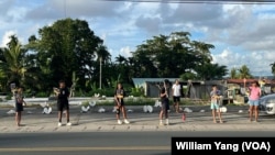 Palauans hold election signs along the streets of Koror ahead of Palau's Nov. 5 general elections.