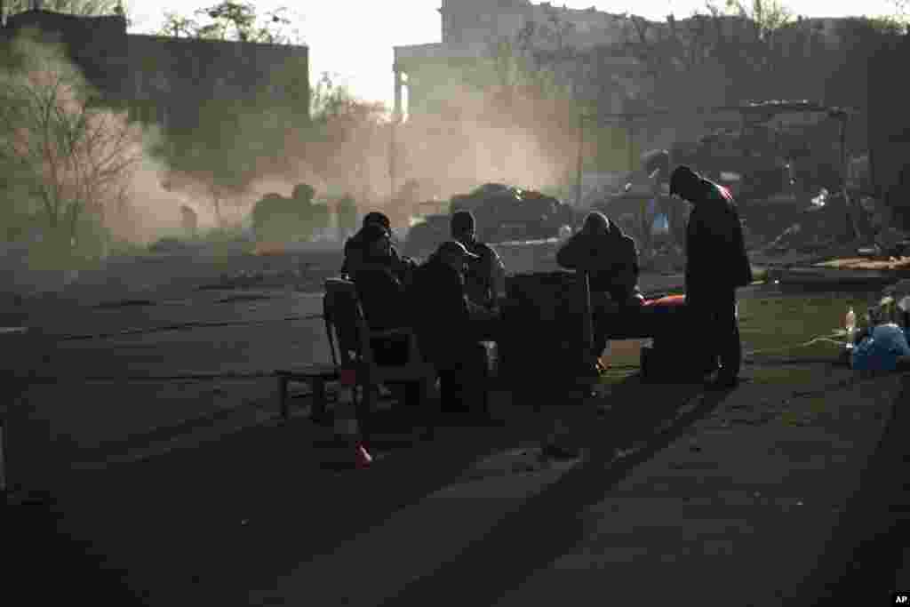 Opposition supporters warm themselves around a fire as they guard one of the streets heading to Kyiv's Independence Square, Feb. 24, 2014. 