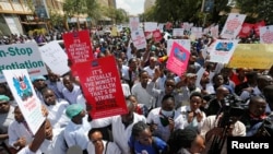 Striking doctors hold placards and chant slogans outside the Court of Appeal as they wait for the release of jailed officials of the national doctors' union in their case to demand fulfillment of a 2013 agreement between their union and the government that that would raise their pay and improve working conditions in Nairobi, Kenya, Feb.15, 2017.