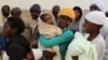 Zimbabwean women react as they wait to casts their votes at a polling station in Domboshava, about 45 km (28 miles) north of Harare July 31, 2013. Zimbabweans voted in large numbers on Wednesday in a fiercely contested election pitting veteran President R