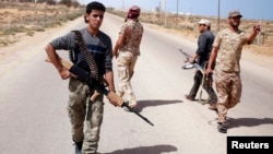 FILE - Libya Dawn fighters search for Islamic State militant positions during a patrol near Sirte.