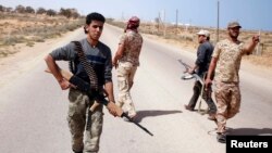 FILE - Libya Dawn fighters search for Islamic State militant positions during a patrol near Sirte.