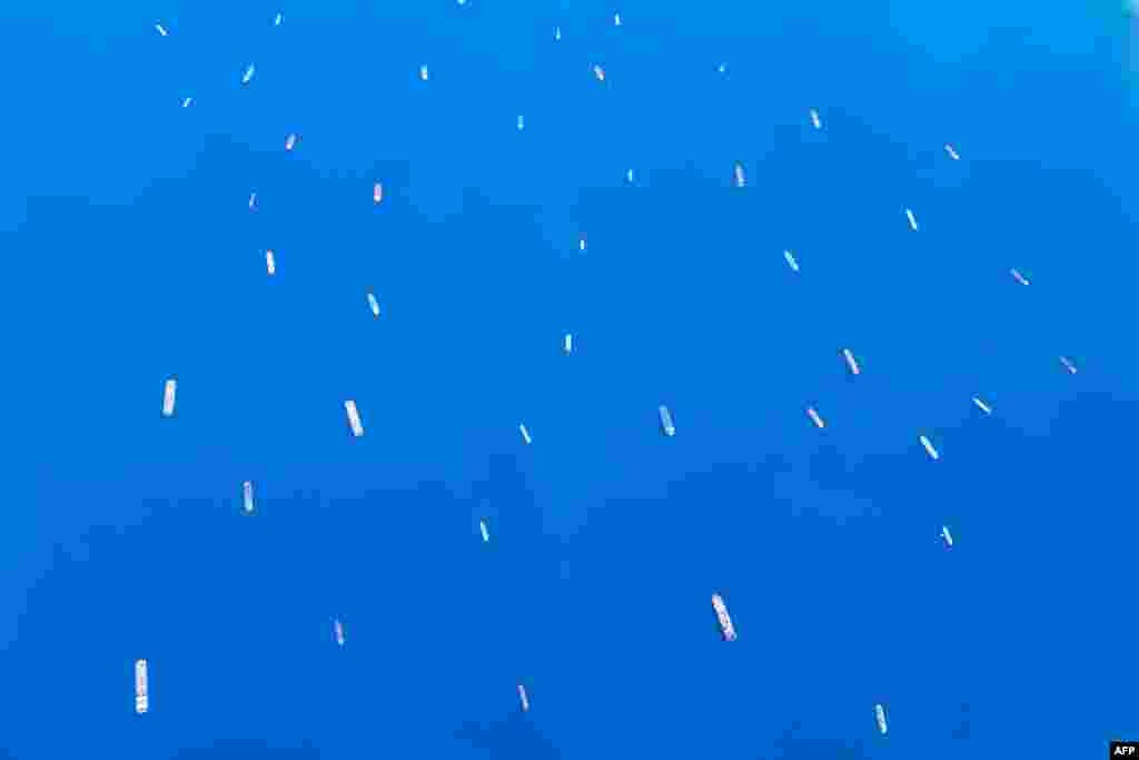 An aerial view shows stranded ships waiting in queue in the Gulf of Suez, March 27, 2021, to cross the Suez Canal as the waterway remains blocked by the Panama-flagged container ship &quot;MV Ever Given&quot;, which has remained wedged sideways since March 23.