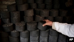 A man stocks up coal briquettes at his court yard, as many people living in old houses still rely on coal fire to heat up in the winter season, in Beijing, China, Nov. 18, 2014.