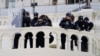 پلیس کنگره تظاهرکنندگان را که تلاش می کردند موانع پلیس را پشت سر بگذراند زیر نظر دارند. واشنگتن، ۶ ژانویه ۲۰۲۱