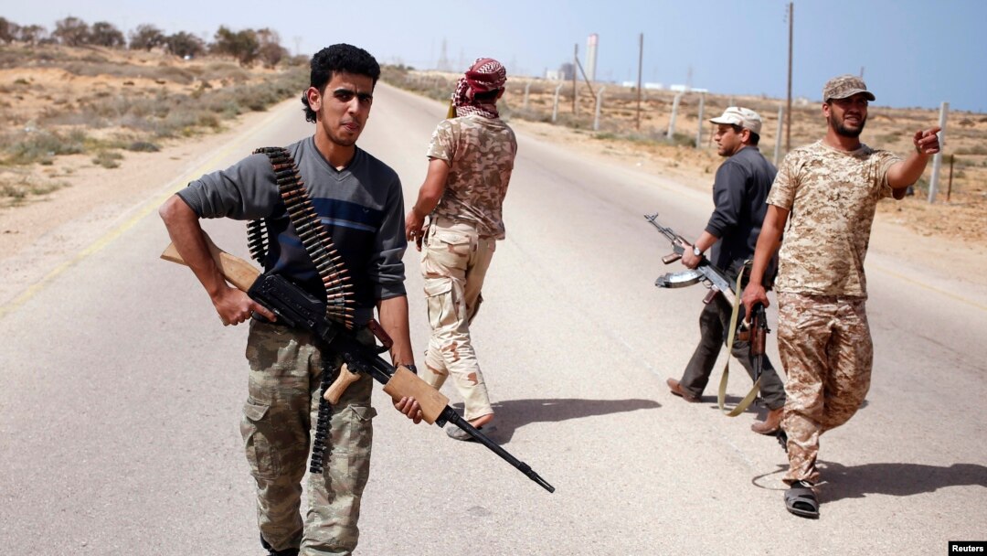 FILE - Libya Dawn fighters search for Islamic State militant positions during a patrol near Sirte.