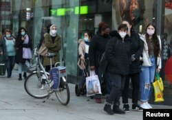 People queue in front of a shop, as the coronavirus disease outbreak continues, in Frankfurt, Germany, Dec. 14, 2020.