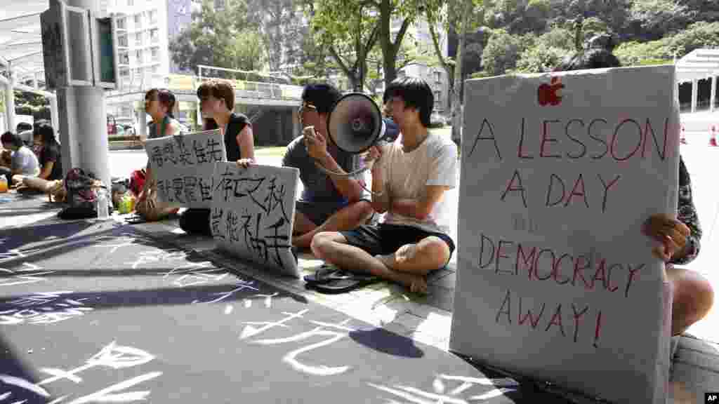 دانشجويان طرفدار دمکراسی در پرديس دانشگاه چينی در هنگ کنگ حاضر شده اند و پلاکاردهای خود را به بقيه دانشجويان نشان میدهند و از آنان میخواهند درس نخوانند و به صفوف تظاهرات بپيوندند&nbsp;-- ۱۴ مهرماه ۱۳۹۳ (۶ اکتبر ۲۰۱۴) 