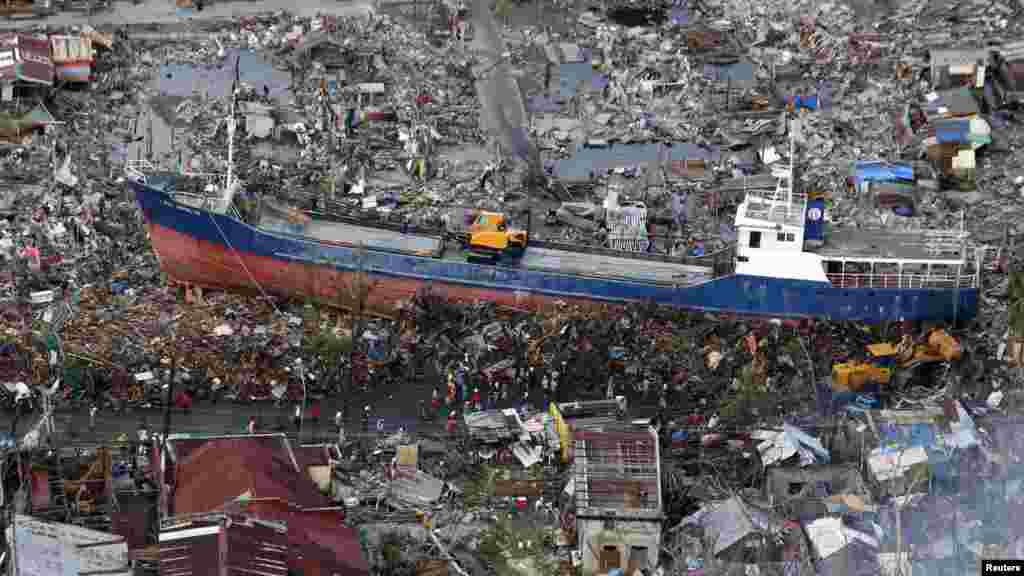 Residents look at a ship that was swept by Typhoon Haiyan nearly two weeks ago, in downtown Tacloban city in central Philippines, Nov. 21, 2013.
